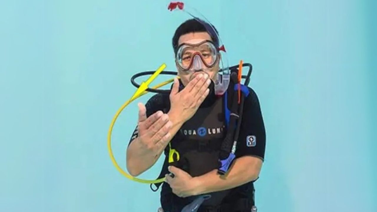 Diver making share air signal underwater